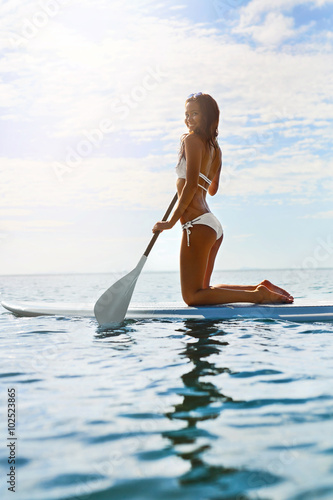 Recreational Water Sports. Healthy Happy Fit Woman With Sexy Body Paddling  Kneeling On Stand Up Paddle  Surf Board In Sea. Summer Holidays Travel Vacation. Active Lifestyle. Leisure Activity. Hobby