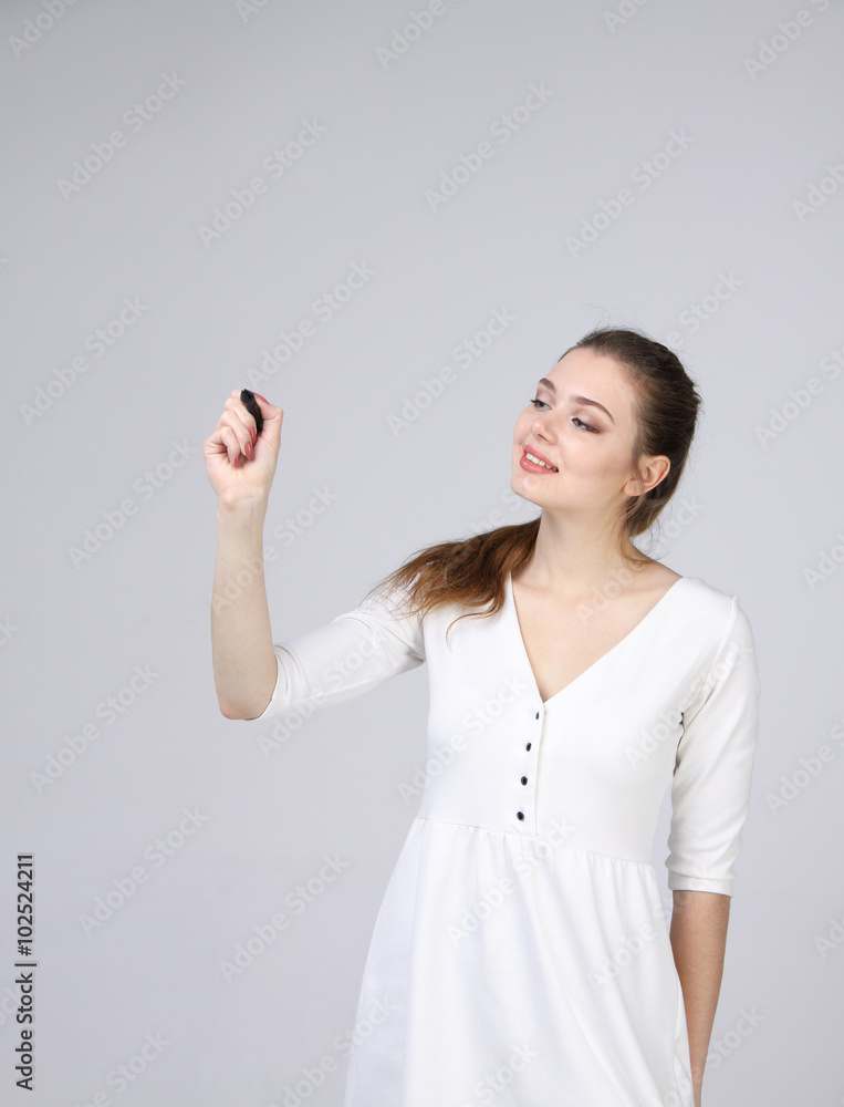 young woman with pen on grey background young woman with pen on grey background