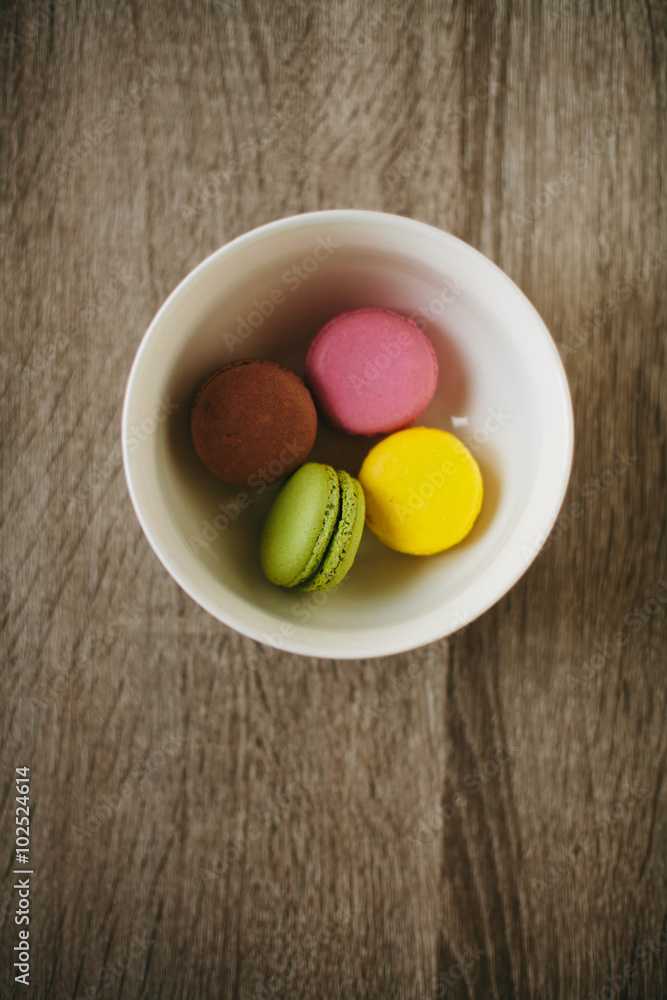 Macaroons on the wooden table with golden ribbon. Macaroons on the wooden table with golden ribbon.