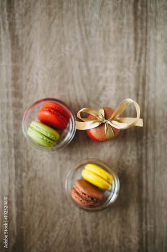 Macaroons on the wooden table with golden ribbon.