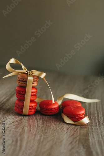 Macaroons on the wooden table with golden ribbon.