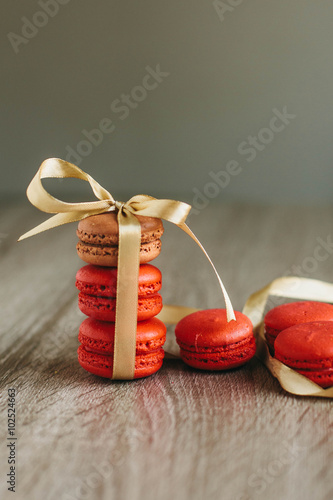 Macaroons on the wooden table with golden ribbon.