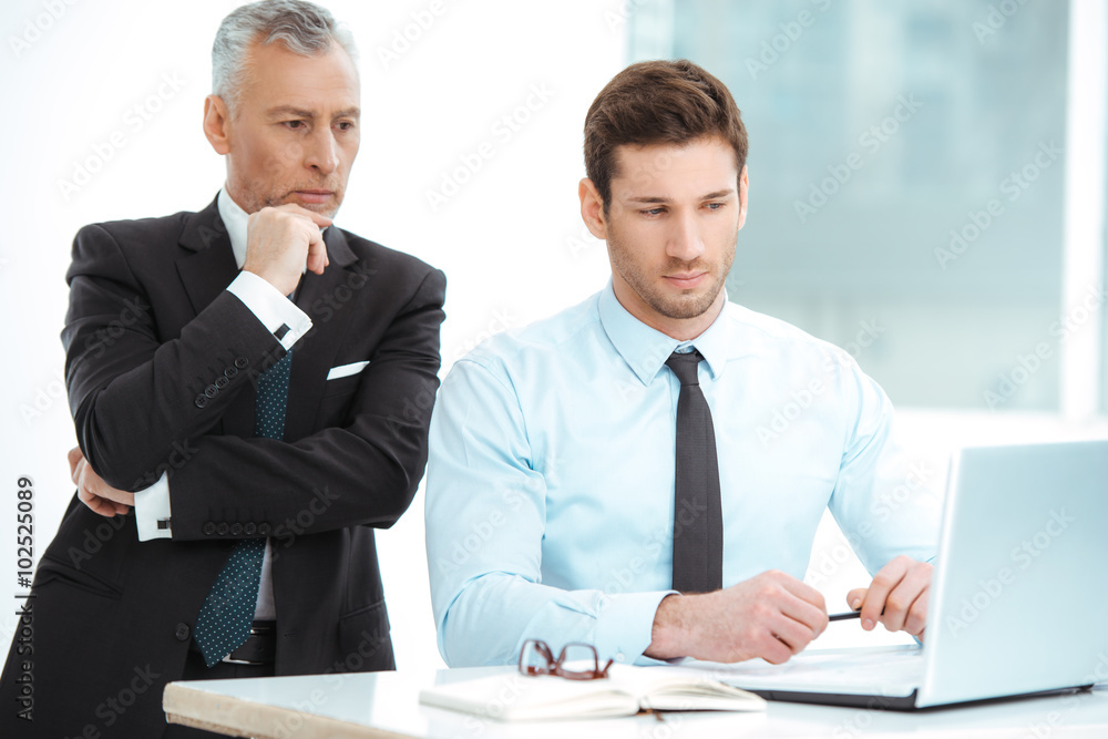 Aged and young businessmen having meeting