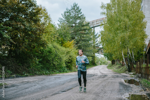 Man running on an old road in green nature.