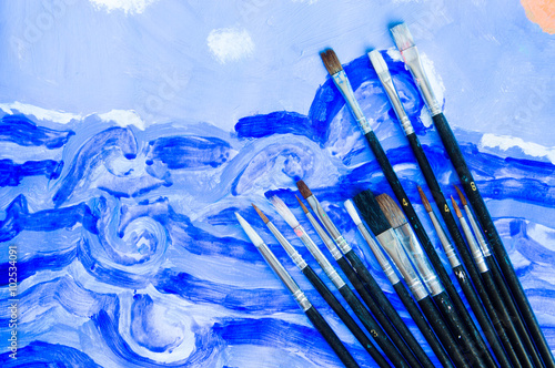 Illustrator paintbrushes on blue watercolor draw background