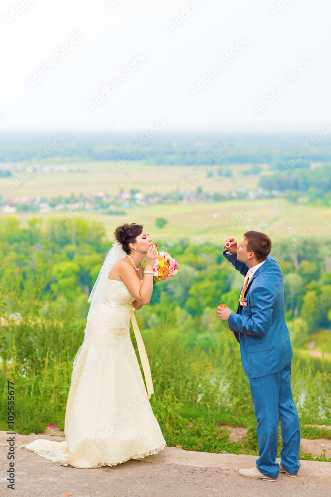 beautiful wedding couple blowing bubbles
