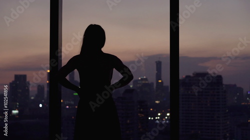 Young woman looking at cityscape at night
