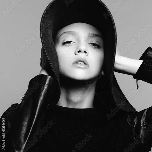 Portrait of beautiful girl in hat, posing in studio, black and white photography