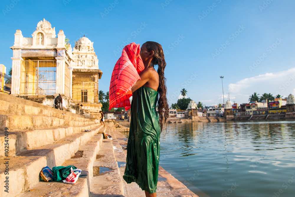 Indian woman bathes in the sacred lake Mahamaham.in the town of Kumbakonam, Tamil Nadu, India