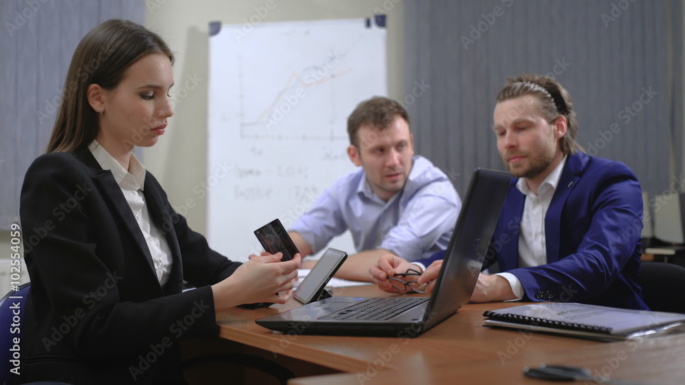 Pretty young woman in the office. Paying with a credit card Pretty young woman in the office. Paying with a credit card