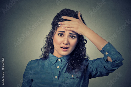 woman looking shocked, surprised, hand on head stressed realized mistake