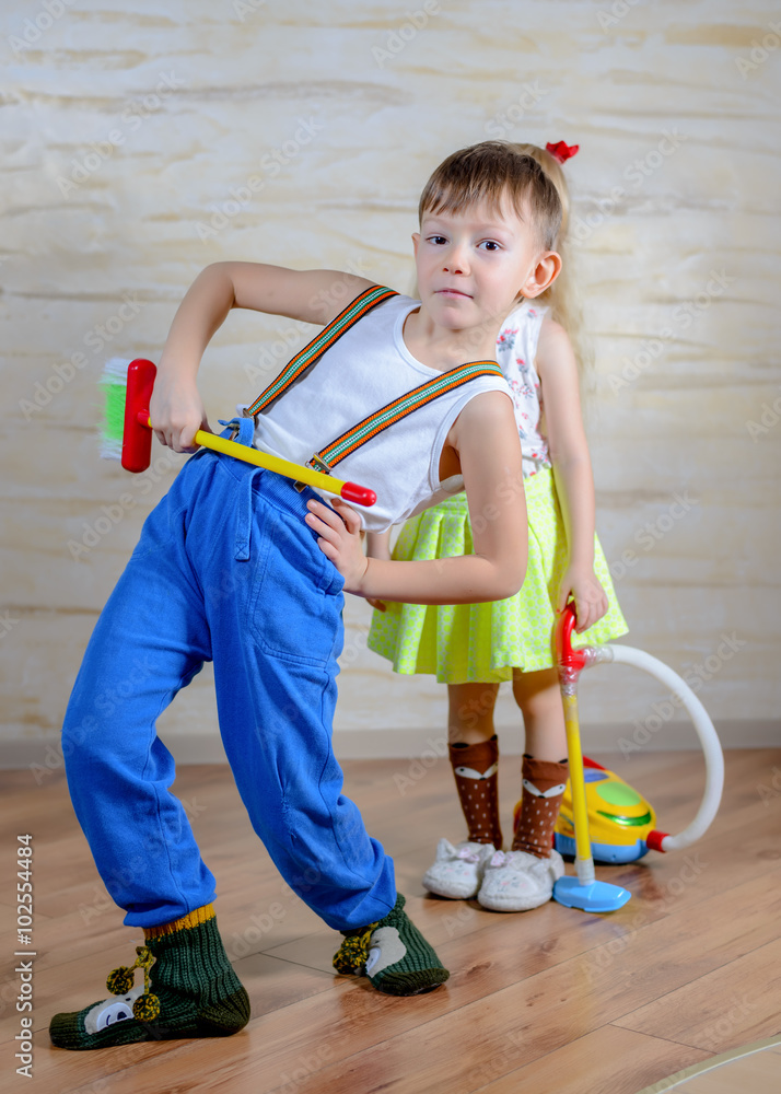 Fototapeta premium Cute playful little boy and girl cleaning house