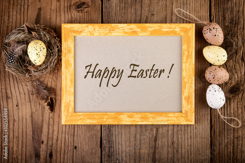 Easter decoration on old wood vintage style. Yellow wooden frame with text Happy Easter.