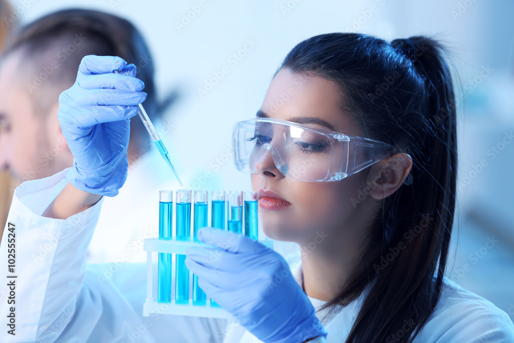 Young medical technicians working in laboratory Young medical technicians working in laboratory