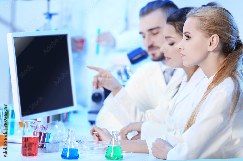 Young medical technicians working in laboratory Young medical technicians working in laboratory