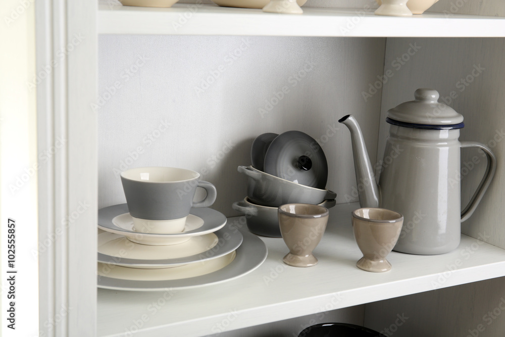 Tableware on shelf in the kitchen cupboard Tableware on shelf in the kitchen cupboard