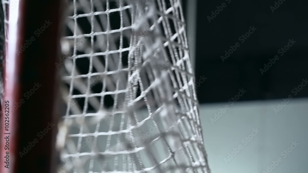 Close-up shot of hockey puck flying into goal and hitting net in slow motion Close-up shot of hockey puck flying into goal and hitting net in slow motion