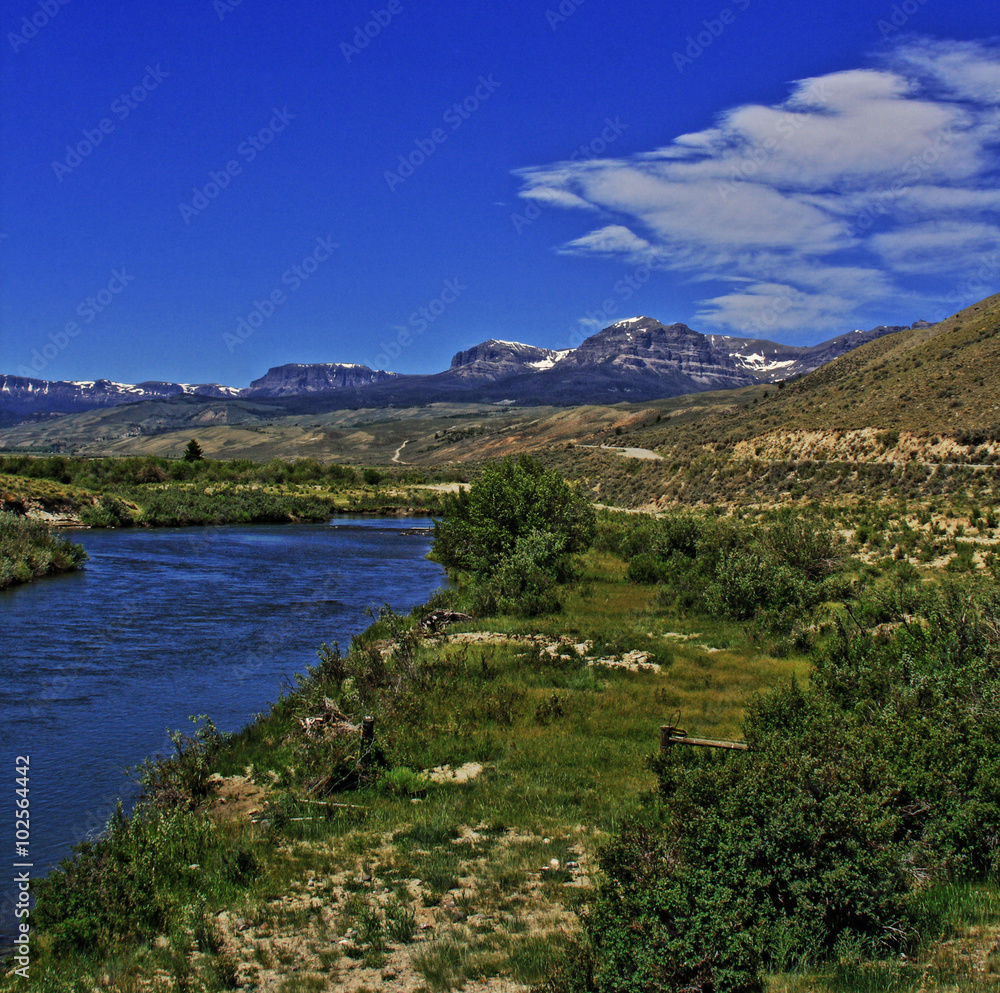 Du Noir Creek just outside of Dubois Wyoming with Breccia Cliffs and Breccia Peak in the background on Togwotee Pass Absaroka Mountains during the summer in Wyoming USA with wispy clouds over head.