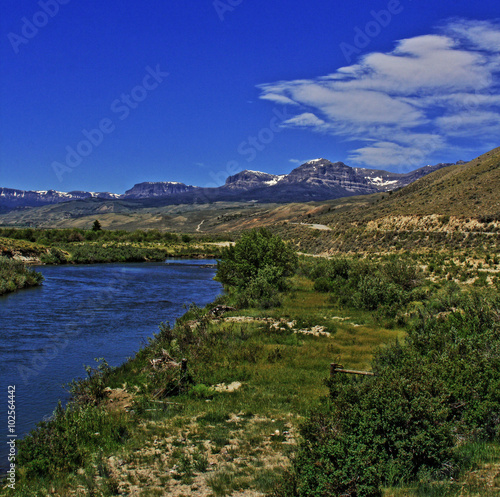 Du Noir Creek just outside of Dubois Wyoming with Breccia Cliffs and Breccia Peak in the background on Togwotee Pass Absaroka Mountains during the summer in Wyoming USA with wispy clouds over head. photo
