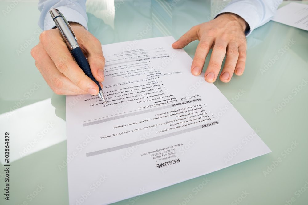 Businessperson With Resume At Desk Businessperson With Resume At Desk