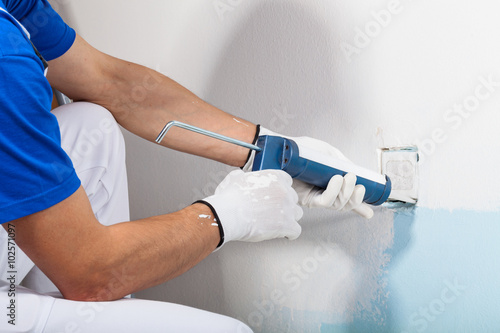 Professional Workman Applying Silicone Sealant With Caulking Gun