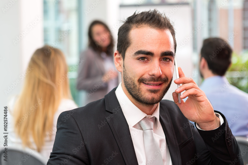 Young attractive businessman working at the office with associat Young attractive businessman working at the office with associat