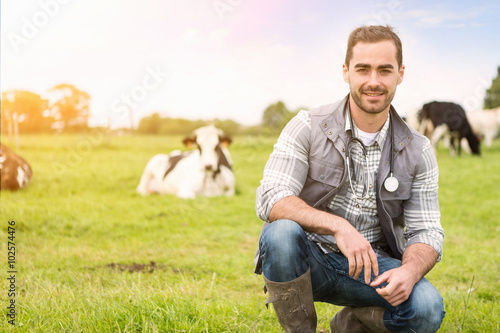 Portrait of a Young attractive veterinary in a pasture with cows photo