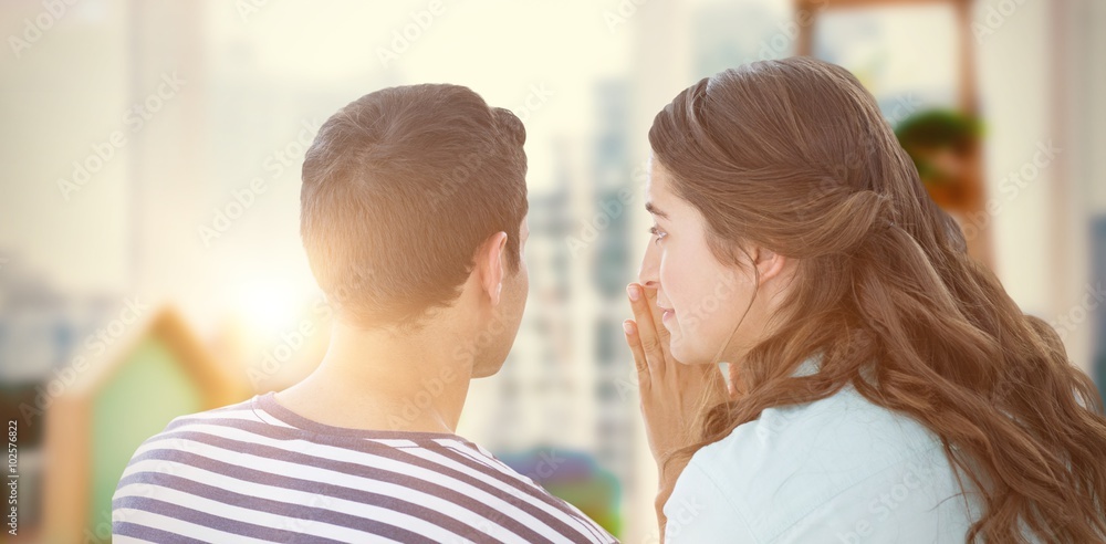 Fototapeta premium Composite image of woman whispering secret to boyfriend