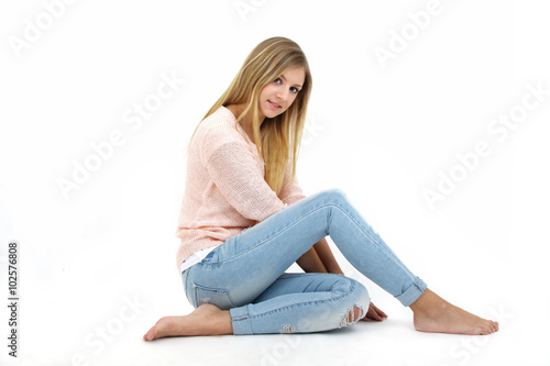 Frau in Jeans sitzt auf dem Boden