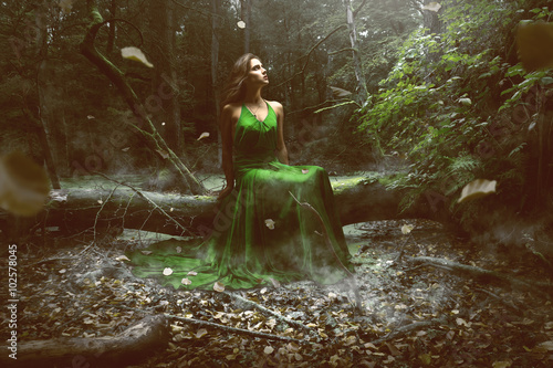Woman wears a green dress in the forest photo