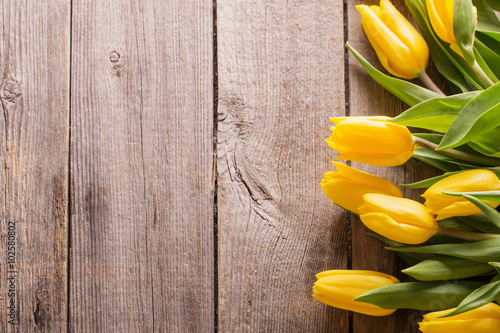 Fototapeta Naklejka Na Ścianę i Meble -  yellow tulips over wooden table background