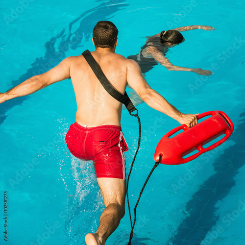 Konstfotografi Lifeguard jumping towards drowning victim in the pool