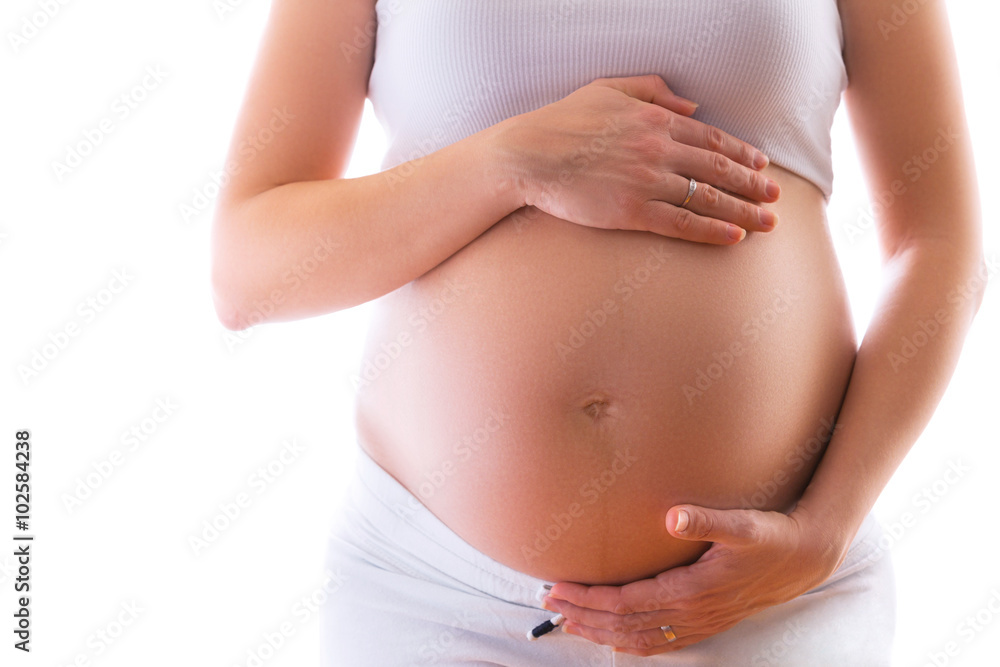 Close up of a pregnant woman gently holding her bally
