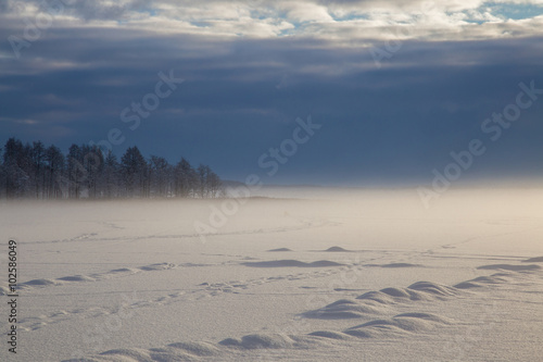 Mist over the lake with impressive clouds during the winter