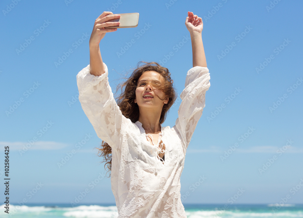 Carefree young woman taking selfie at the beach Carefree young woman taking selfie at the beach