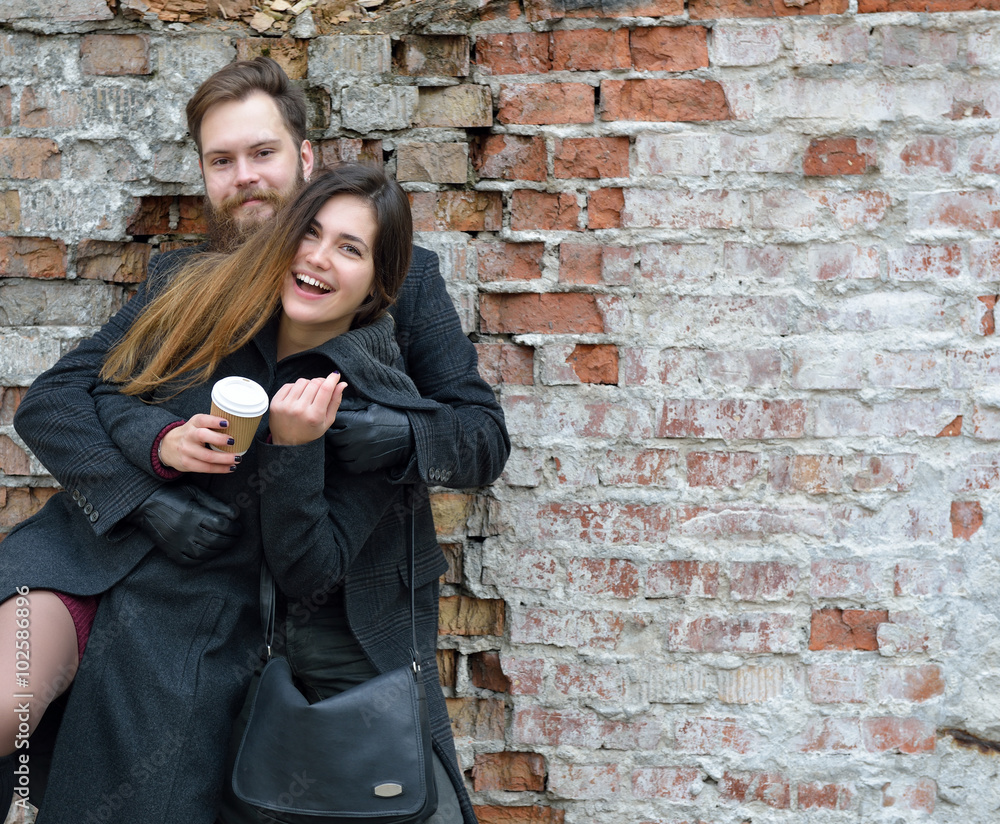 Fashion portrait of young couple drinking coffee in autumn outdo