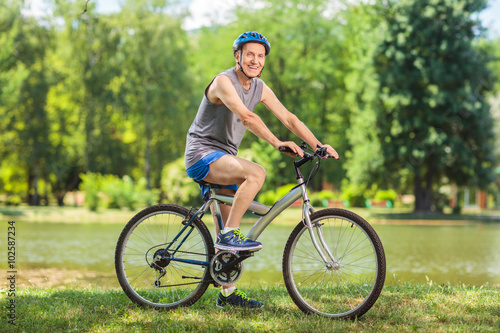 Active senior man riding a bike in park