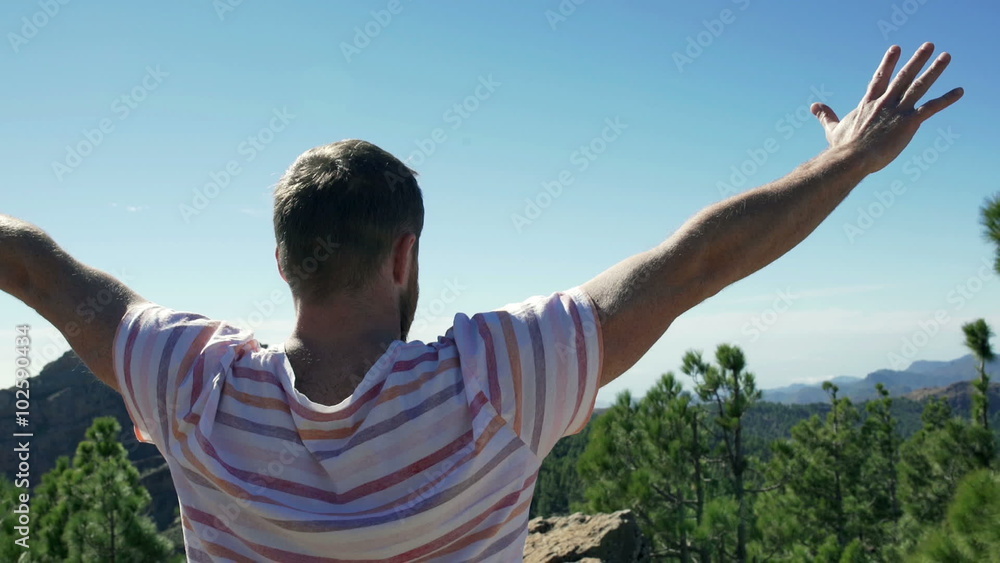 Happy man standing in the mountains and holding hands up
Happy man standing in the mountains and holding hands up
