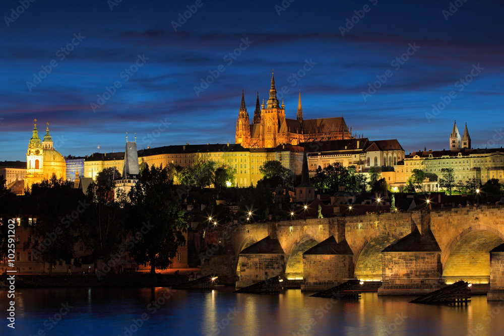 The Prague Castle, gothic style, largest ancient castle in the world, and Charles Bridge are the symbols of Czech capital, built in medieval times. Twilight view of Prague, after sunset