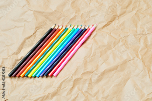 matite colorate su un foglio stropicciato di carta da pacchi