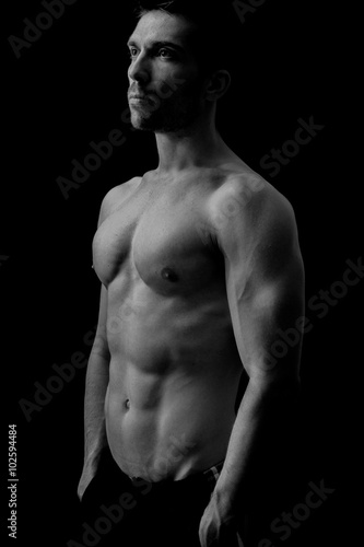 Muscular man posing in black and white 