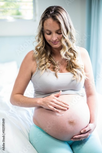 Free Download Pregnant woman applying cream on her belly - GFXLoad