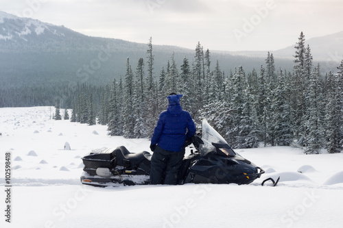 Woman on snowmobile in the mountains.