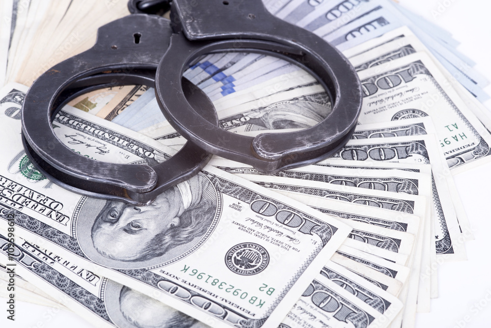Crime and Money. Handcuffs are on the dollar Crime and Money. Handcuffs are on the dollar