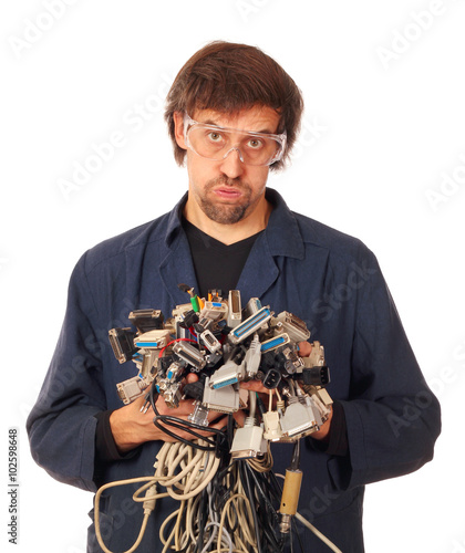 Tired computer engineer holding many different interface cables, wires, connectors, sockets and plugs. Isolated on white background photo