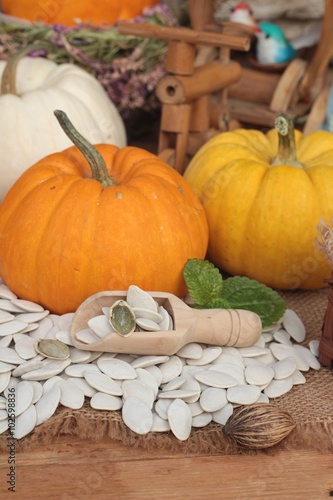 Pumpkin with pumpkin seeds on wood background.