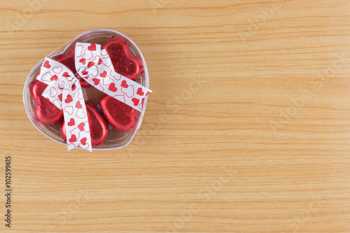 chocolate candy red heart in gift box with ribbon on wooden back