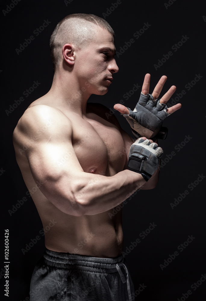 Brutal man fighter wear gloves on dark background