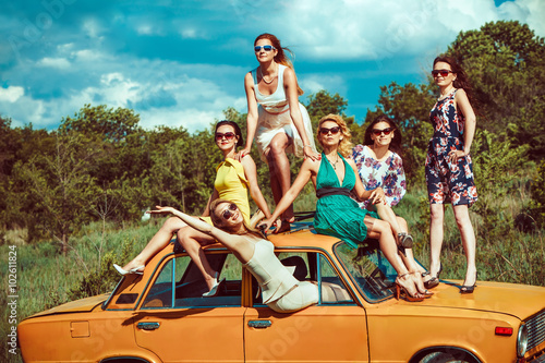 Six beautiful woman on the old car.
