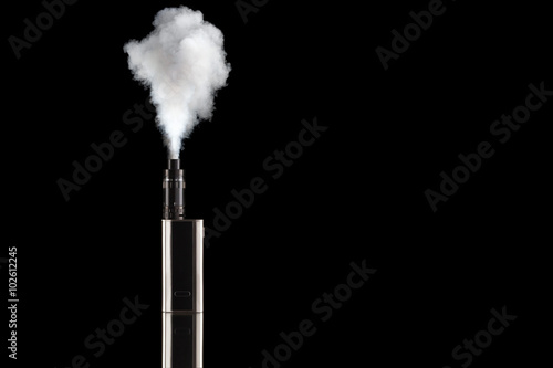 Battery mod or e-cigarette with tank at smoke on black background